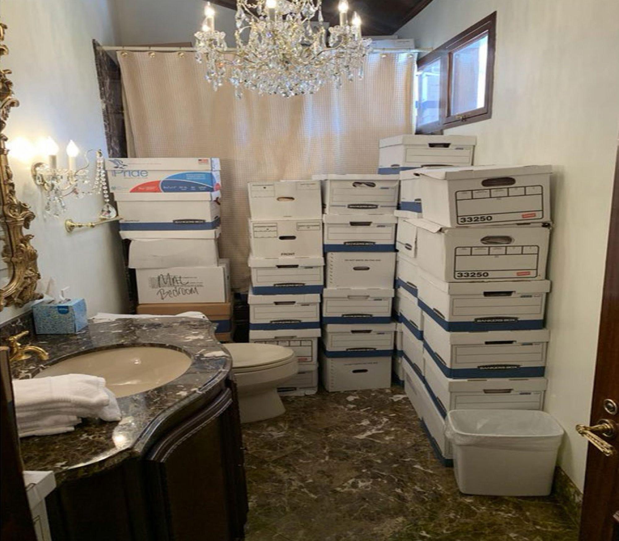 Boxes full of classified documents stacked high in one of Mar a lago's tacky bathrooms.